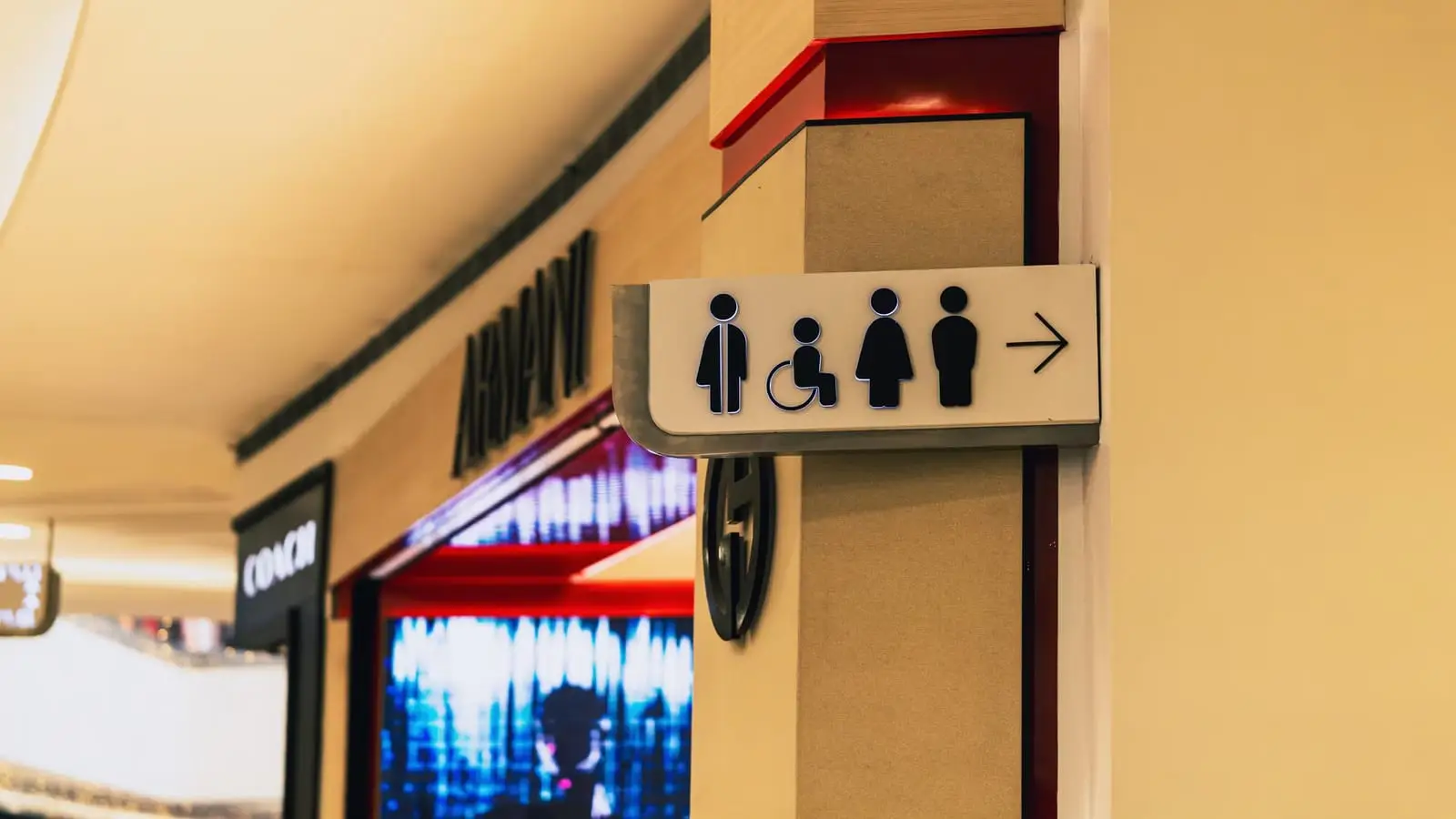 Directional sign showing accessible and standard restroom facilities