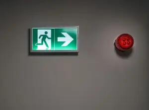 Illuminated emergency exit sign in a building corridor
