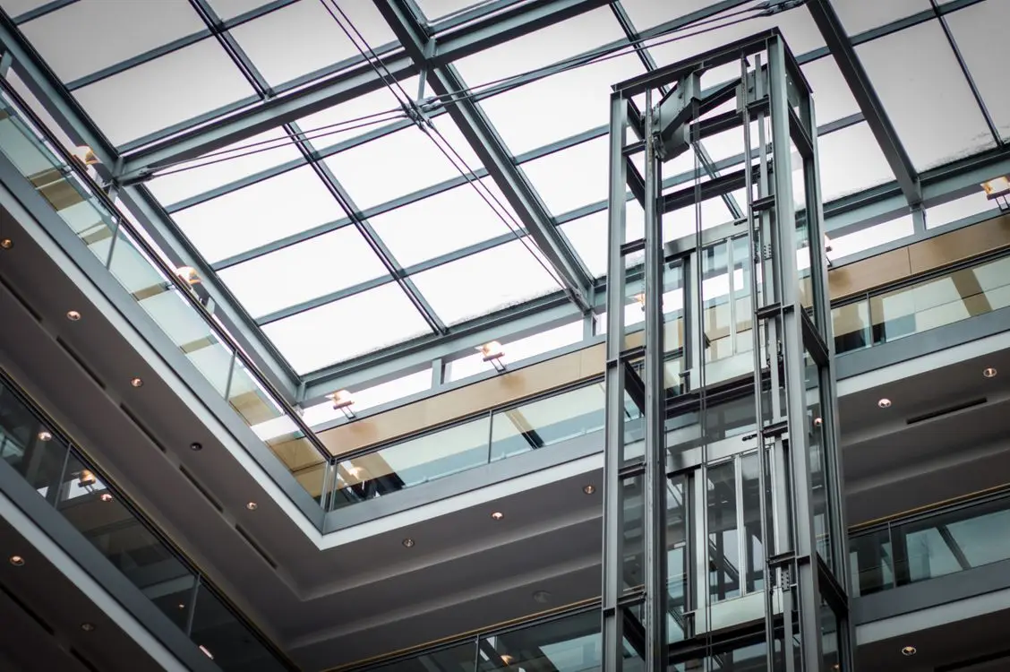 Glass lift structure in a bright modern atrium