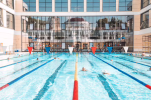 Outdoor swimming pool beside a glass building facade