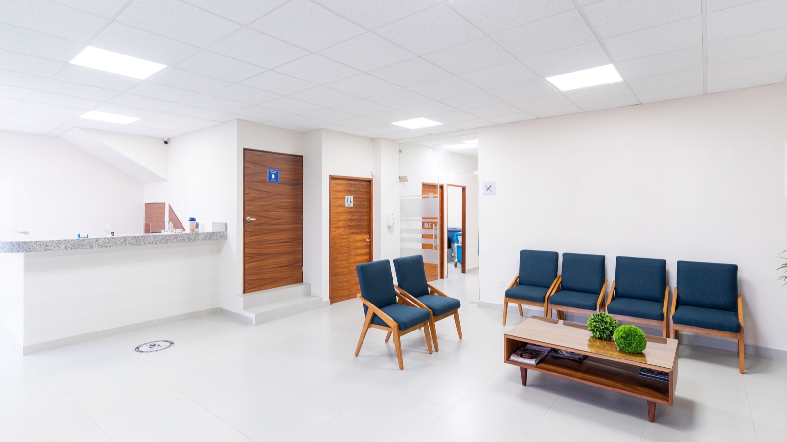 Bright medical centre waiting room with reception counter and seating